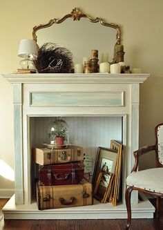 a white fireplace with suitcases stacked on top