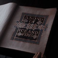 an open book with the words a song of ice and fire on it's cover