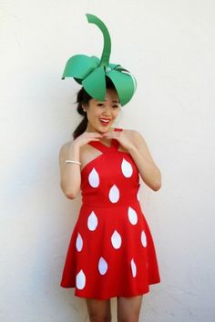 a woman wearing a red and white polka dot dress with a green hat on her head