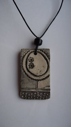 a ceramic pendant with an artistic design on it