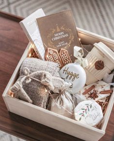 a wooden box filled with assorted items on top of a table next to a christmas tree