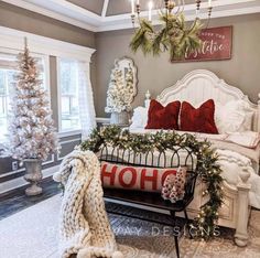 a bedroom decorated for christmas with white furniture and holiday decorations on the bed, along with wreaths