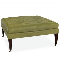 a green ottoman sitting on top of a wooden table