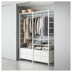 an open closet with white drawers and clothes