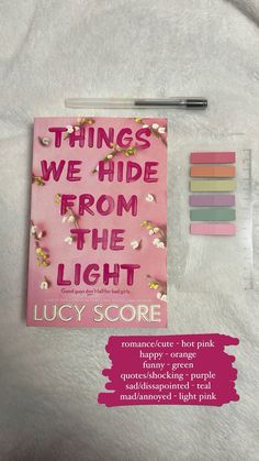 there is a pink book with writing on it and some other items next to it