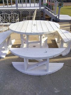 a white picnic table and benches in front of a gazebo