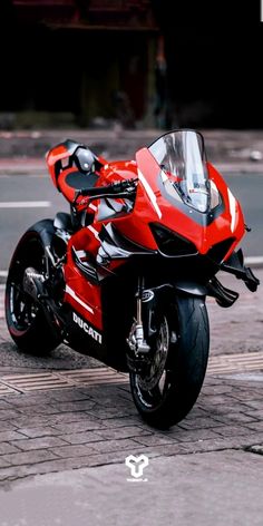 a red motorcycle is parked on the street