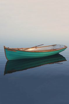 a small green boat floating on top of a body of water