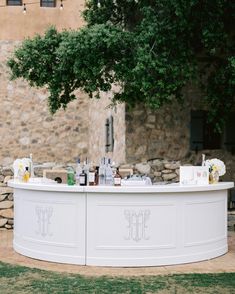 an outdoor bar is set up with bottles and glasses on the counter for guests to drink