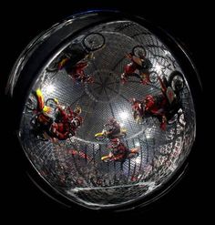 a group of people riding bikes on top of a metal cage in the dark,