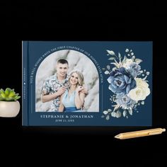 a photo book with an image of two people and flowers on it, next to a pen