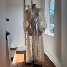 This Piece Is Absolutely Stunning. Unknown If Ever Worn But It’s In Great Condition. The Only Flaws Are Some Of The Sequins On The Lace Over Coat Have Started To Yellow, Otherwise Mint Condition. Stunning Vs Vintage ‘80’s 2 Piece Night Lace Ivory Coat With Matching Silk And Lace Pleated Nightgown Both Sz: Small Coat Has Long Tail In The Back, Faux Pearl Double Button Closure In The Front, White Sequins And Beaded Details Throughout Both Pieces Coat Measurements: Pit To Pit 25” Waist Straight Acr Fitted Lace Sleeves Wedding Robe, Fitted Wedding Robe With Lace Sleeves, Fitted Sheer Robe For Wedding, Sheer Lace Wedding Robe, Cream Wedding Night Gown With Lace Trim, Long Wedding Robe With Lace Trim, Cream Floor-length Gown For Wedding Night, Cream Lace Trim Wedding Robe, Cream Silk Gown For Wedding Night