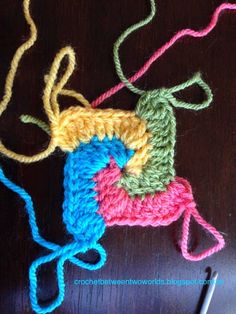 three crocheted grannys sitting on top of a wooden table