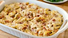 a casserole dish with meat and cheese in it sitting on a wooden table