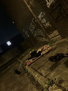 a person laying on the ground next to a building