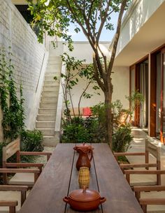 a wooden table with a vase on it in the middle of a patio area next to stairs