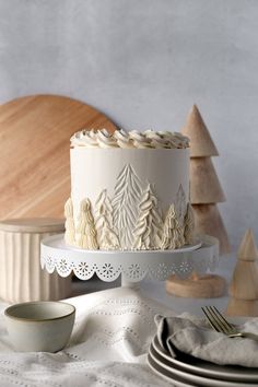 a white cake sitting on top of a table next to plates and bowls filled with food