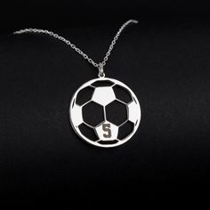 a soccer ball necklace with the number 5 on it's front and back side