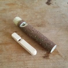 a knife is laying on the ground next to a piece of wood that has been cut in half