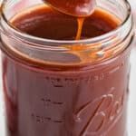 a spoon full of liquid being poured into a jar