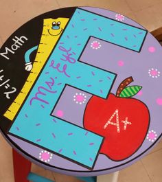 a child's table with the letter e on it and an apple painted on top