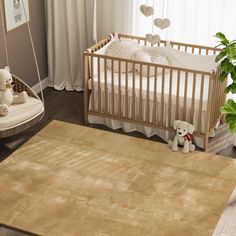 a baby's room with a crib, rocking chair and teddy bear on the floor