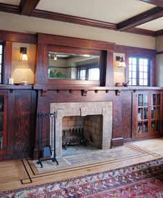 a living room with a fire place and bookshelves on the wall next to it