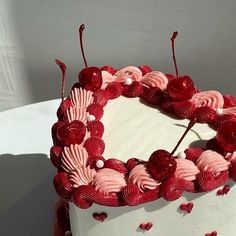 a white cake with red icing and hearts on it