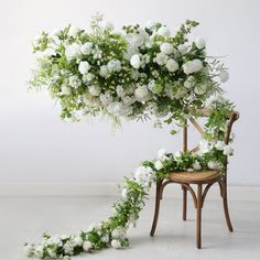 a chair with flowers and greenery on it