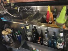 the kitchen sink is full of bottles and other liquors, including one for sale