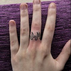 a person's hand with a small tattoo on it