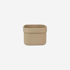 a small beige pot sitting on top of a white surface with the lid closed and no handles