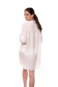 The Lydia is a button-up cover-up that can double as a shirt for a casual look. The off-white fabric has a light texture, and it is breathable and comfortable. The long sleeves can be folded and secured with a button on the side. One size. one size shoulder to bottom length: 35" (89cm) sleeves length: 21" (54cm) 100% Rayon (Viscose) Chic Long Sleeve Cover-up For Daywear, White Cotton Cover-up For Day Out, Relaxed Fit Long Sleeve Cover-up For Day Out, White Blouse With Shirttail Hem And Placket, White Collared Shirt For Beach, Casual White Oversized Shirt Dress, White Collared Beach Shirt, White Oversized Casual Shirt Dress, White Blouse With Relaxed Fit And Placket