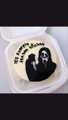 a decorated cake in a foam container with writing on the side and a silhouette of a person holding a knife