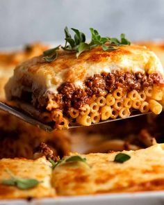 a fork full of lasagna casserole being lifted from the casserole dish