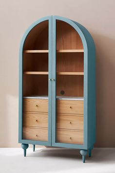 an arch - shaped bookcase with drawers sits against a wall