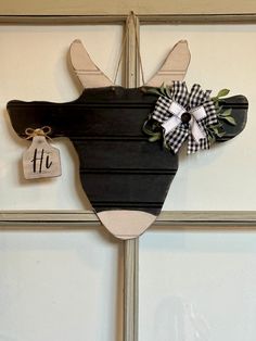 a wooden moose head hanging on the side of a door with a tag attached to it