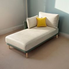 a white couch sitting next to a window on top of a hard wood floor in front of a blue wall