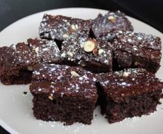 a white plate topped with brownies covered in chocolate