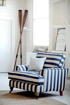 a blue and white striped chair sitting on top of a rug in a living room