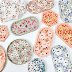 there are many plates that have flowers on them, and one is painted in different colors