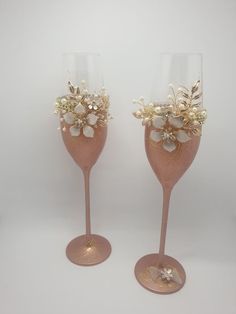 two wine glasses with flowers and pearls on them