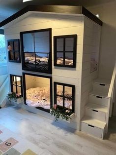 a doll house with stairs leading up to the second floor and two beds in it