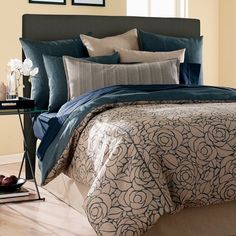 a bed with blue and beige comforters in a bedroom