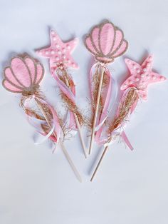 pink and gold mermaid themed cake toppers on sticks with glitter stars in the background