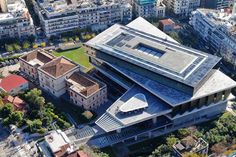 an aerial view of a building in the middle of a city with lots of tall buildings