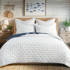 a bed with white comforter and pillows in a room next to two nightstands