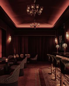 a dimly lit room with several chairs and stools in front of a long bar