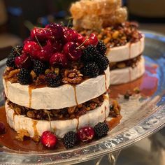 two desserts on a silver platter topped with berries and granola toppings