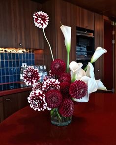 a vase filled with flowers on top of a red table